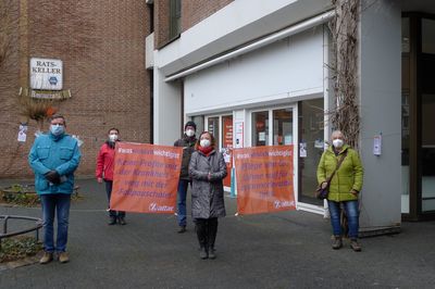 Attacis stehen mit #Waswirklichwichtigist Bannern vor einem Krankenhaus
