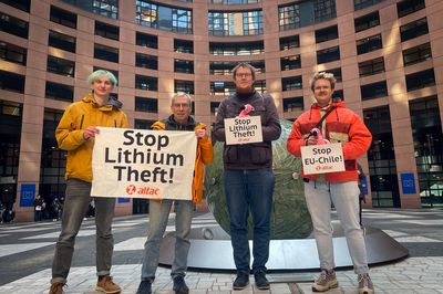 Im Innenhof des Europäischen Parlamentes halten Aktivist*innen ein Banner mit dem Spruch "Stop Lithium Theft!" und zwei Plüschflamingos die kleine Banner mit dem Spruch halten.