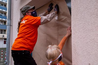 Attac-Aktivist klebt Vonovia Fensterscheibe mit Packpapier ab