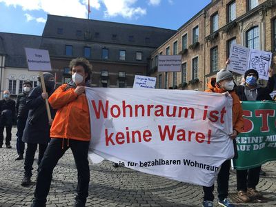 Zwei Attacis halten ein Banner mit der Aufschrift "Wohnraum ist keine Ware!"