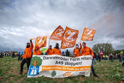 Gruppenbild von Attacies mit Fahnen und Banner "Dannenröder Forst retten, A49 Stoppen - Räumt erstmal die Nazis aus der Polizei"