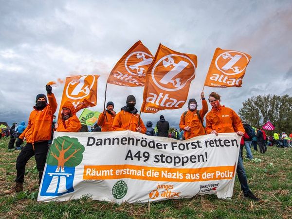 Gruppenbild mit Pyrotechnik und Banner mit dem Spruch "Dannenröder Forst retten, A49 stoppen!" Untertitel: "Räumt erstmal die Nazis aus der Polizei"
