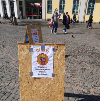 In der Fußgängerzone stehen Aufsteller mit Attac-Plakaten zum Housing-Action-Day