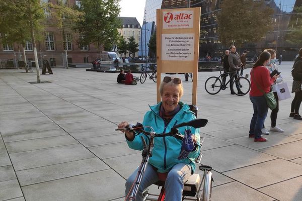 Aktivistin auf Fahrrad mit Schild auf der Gesundheitskundgebung in Freiburg