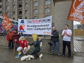 Aktivist*innen von Attac halten ein Transparent mit der Aufschrift "Tax - the rich - Forum", "Vermögensteuer statt Lobbyparty!"