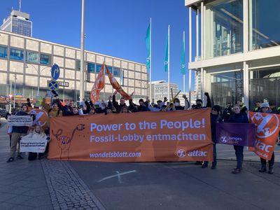 Nach dem Abschluss der Blockade stehen alle Aktivist*innen für ein Gruppenbild zusammen mit dem Transparent mit dem Slogan "Power to the people – Fossillobby entmachten!", Fahnen und Minitransparenten.