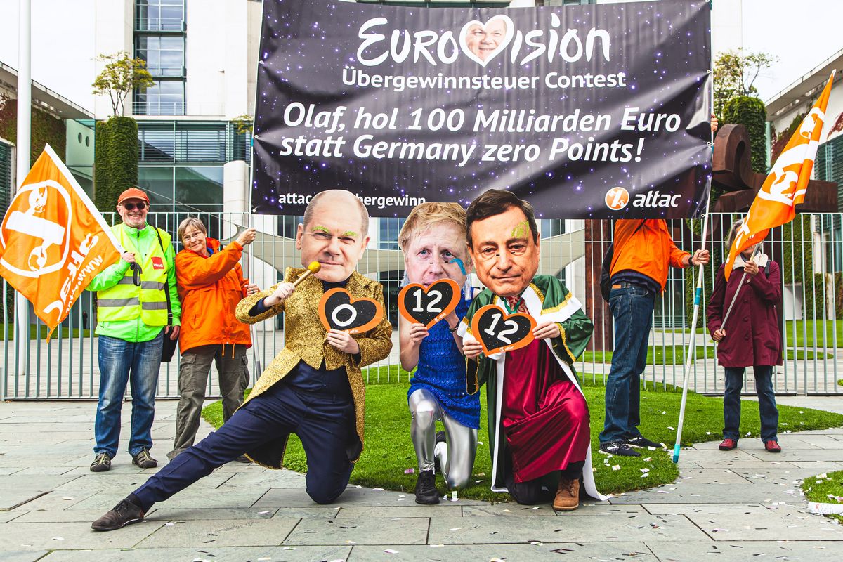 Scholz, Johnson und Draghi hocken vor dem Kanzleramt mit ihren Punkten. Im Hintergrund sieht man das Transparent mit dem Slogan "Eurovision Übersteuergewinn Contest. Olaf, hol 100 Milliarden Euro statt Germany Zero Points"