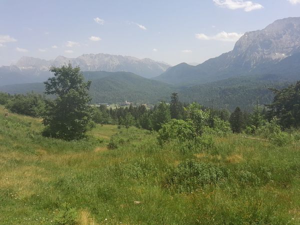 Blick über ein Alpental, im Hintergrund ist klein der G7-Tagungsort Elmau zu erkennen