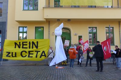 Vor der Grünen Parteizentrale steht eine kleine Demogruppe und hält ein großes Transparent mit der Aufschrift "Nein zu CETA", daneben ist ein überdimensioniertes Taschentuch