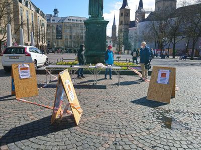 In der Fußgängerzone stehen ein Infostand und Aufsteller mit Attac-Plakaten zum Housing-Action-Day